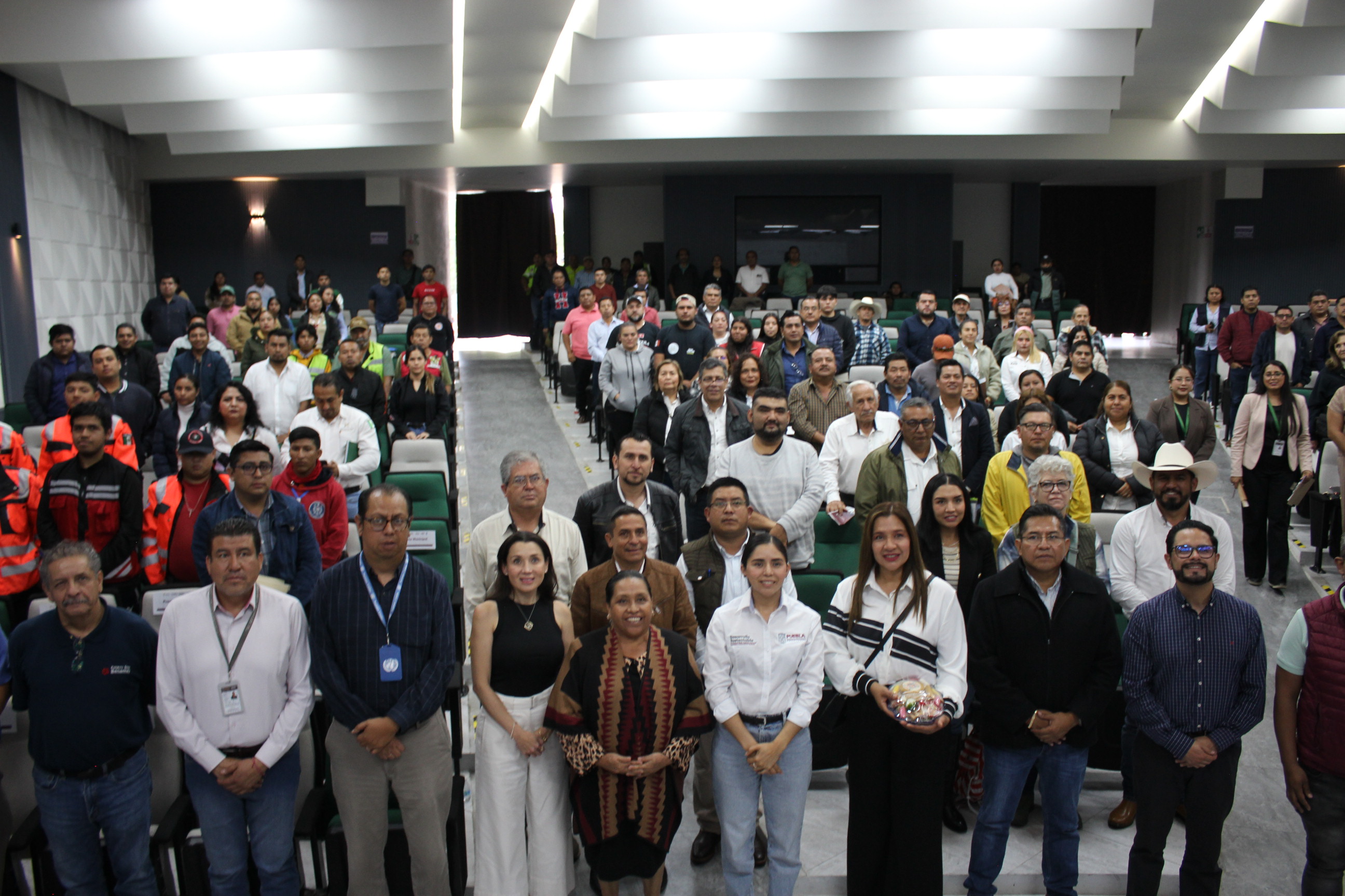 Group photo of a large, diverse crowd in a conference hall.