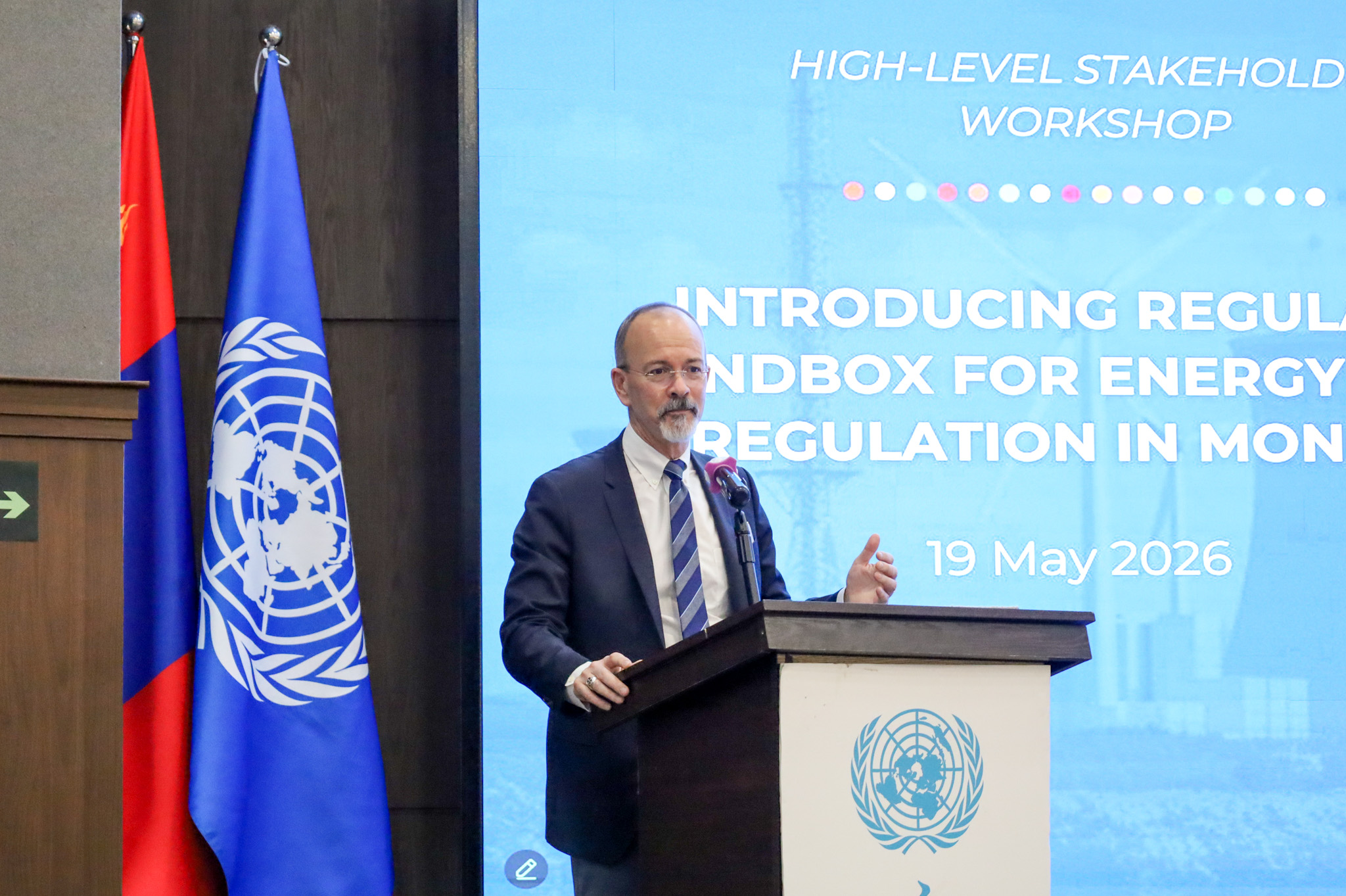 Photograph of a man in a suit speaking at a UN podium during a workshop.