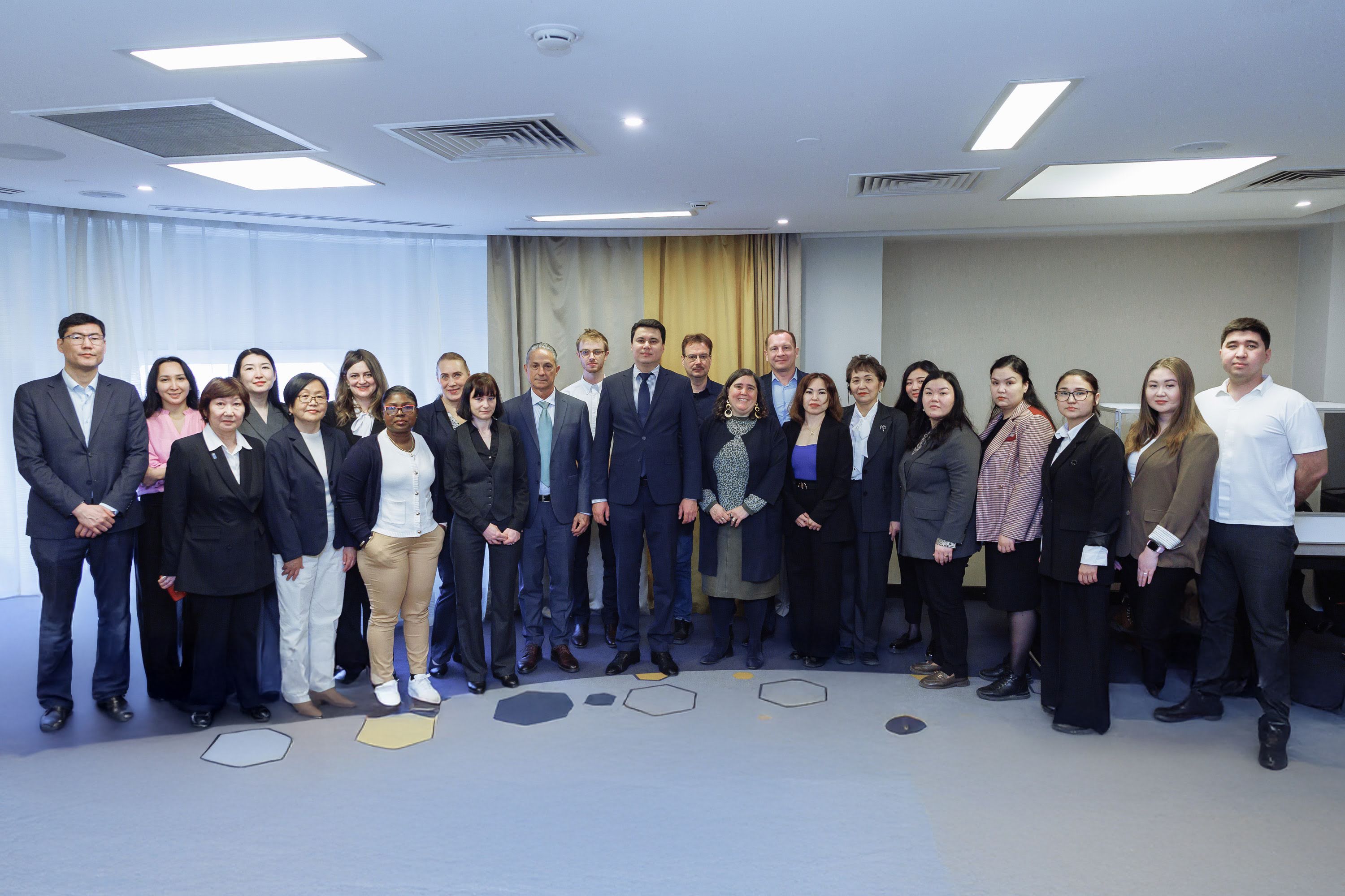 Group photo of professionals in business attire standing in a conference room.