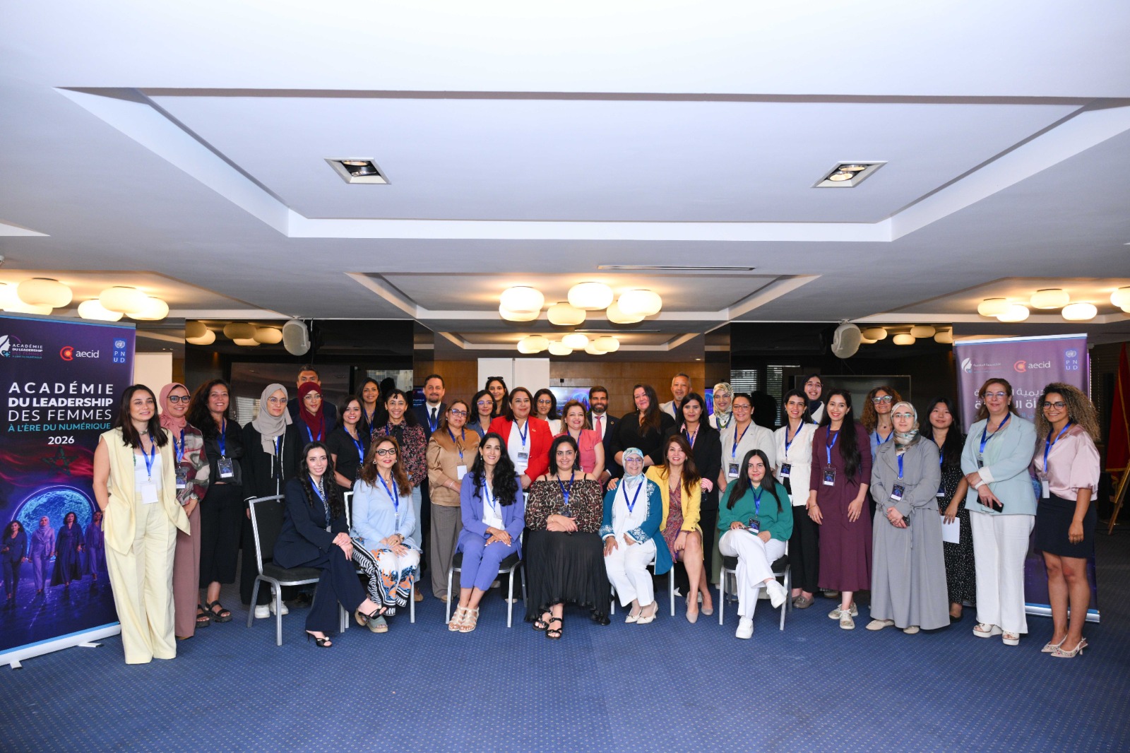 Large group of professionals posing for a group photo in a conference room.