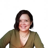 A smiling woman with short, dark hair wearing a green top and layered necklaces.