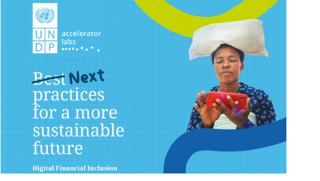 A woman in traditional attire balances a large cloth on her head while using a smartphone.