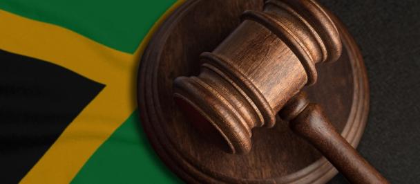 image of a judge's gavel with a Jamaican flag