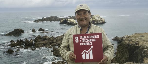 Recolector de algas en Marcona, con cartel de ODS 8: Trabajo decente y crecimiento económico