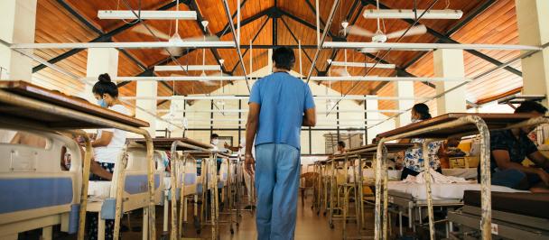 A medical worker walks through a hospital ward.
