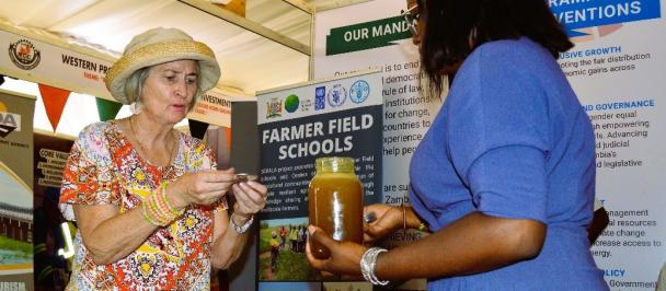 A guest samples Sioma Honey, produced by farmers opting for alternative livelihood in Sioma District, a SCRALA project site