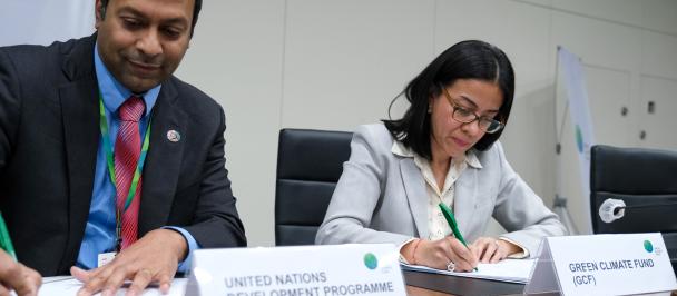 Pradeep Kurukulasuriya signs the new agreement on behalf of UNDP with Carolina Fuentes from the GCF