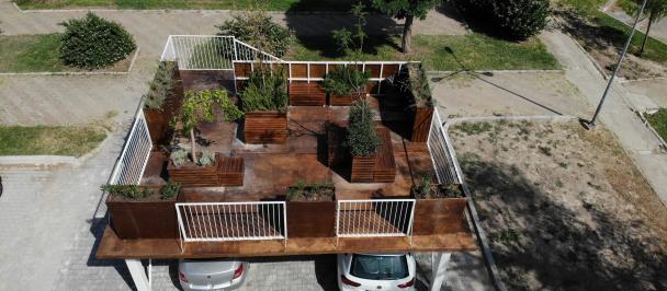 Upper ground space seen from a birds eye view with greenery with cars parked underneath.