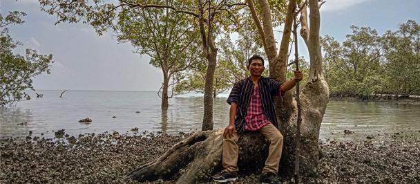 U Myo Oo sits in a mangrove forest in Myanmar's Tanintharyi Region