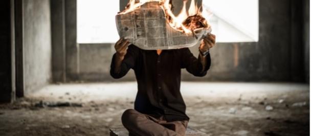 A man with his newspaper on fire.