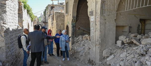 Group of people standing in front of destroyed building