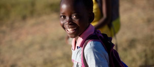 Young girl in school uniform smiles at camera