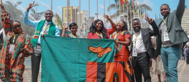 An image of Zambian Youths holding the Zambian flag in Kenya