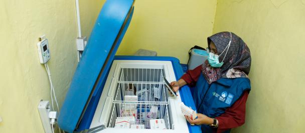 Sri Hartati, a pharmacist at the Bungus community health center in Padang city, West Sumatera is monitoring the temperature of vaccine storage equipped with an IoT logger through the SMILE app.