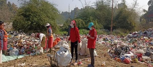 Two ladies sorting and weighing waste at a collection center