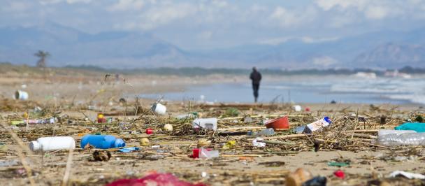 Person walks along littered beach