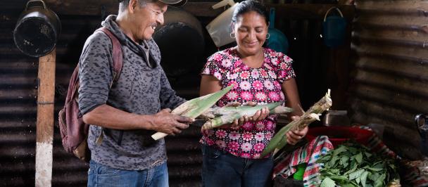 Un hombre y una mujer de pie frente a un pastel