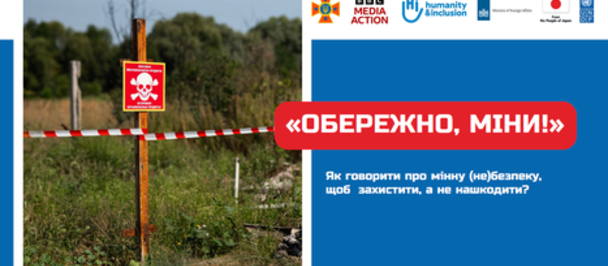 Warning sign indicating the presence of mines, set in a grassy area with trees in the background.