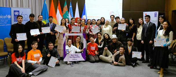 Group photo of diverse attendees at a conference, some holding certificates, with flags and banners.