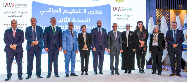 Group photograph of dignitaries on stage at a conference, banners with logos behind.