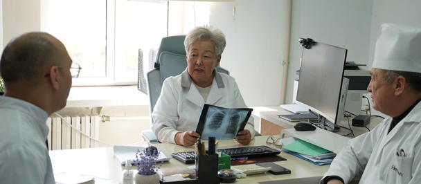 A Chief Physician discusses X-rays with two doctors at a clinic.