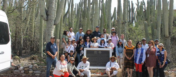 Group of people posing for a photo in a cactus garden.