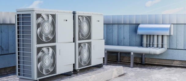 Rooftop HVAC condensers with fans on a platform beside a blue wall, with light snow.