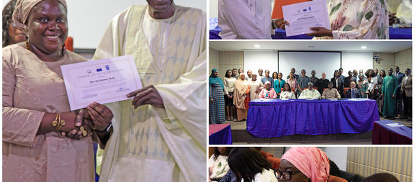 Group at an awards ceremony: smiling couple holds a certificate while others sit at a table.