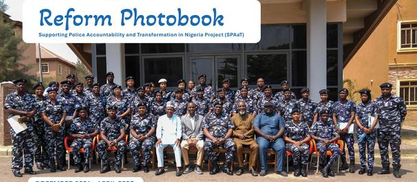 Group of people in blue uniforms posing in front of a building with a Reform Photobook banner.