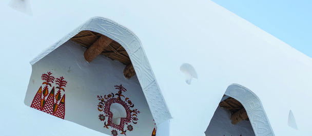 Photograph of a white building with arched openings, blue sky, and UNDP Libya logo.