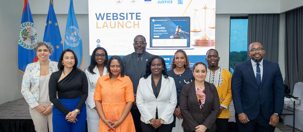 Group of professionals posing at a website launch event; screen behind reads Website Launch.