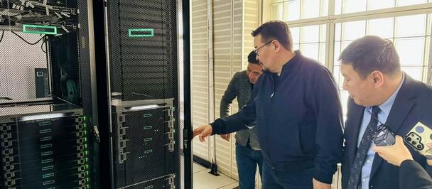 Three men in a data center examine a row of tall black server racks.