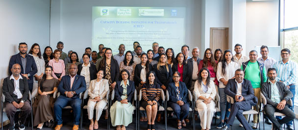 Group photo of diverse professionals in a conference room, smiling.