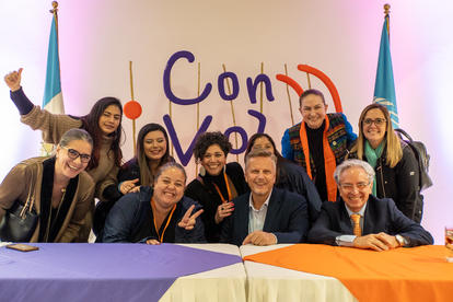 Fotografía que muestra a distintos representantes de las distintas Agencias del Sistema de las Naciones Unidas en Guatemala delante del fondo de la campaña ''Con Voz''.