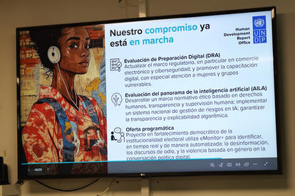 A digital presentation on a screen alongside a portrait of a woman wearing headphones.