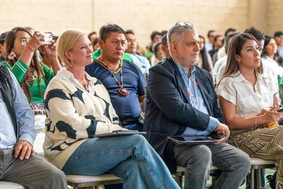 A diverse group of people seated and engaged in a discussion at an event.