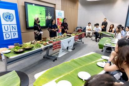 Participants watch a presentation on traditional foods, with a display of dishes on the table.
