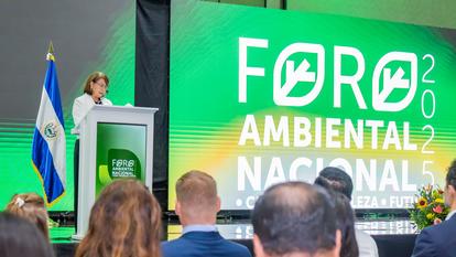 Speaker at podium on stage with green Foro Ambiental Nacional banner; Argentina flag visible.