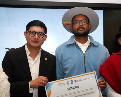 Two people with blurred faces hold a certificate at an awards ceremony.