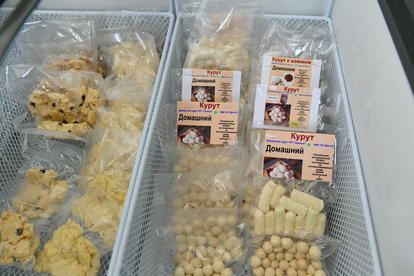 Freezer drawer with three clear bins of cookies and packaged snacks.