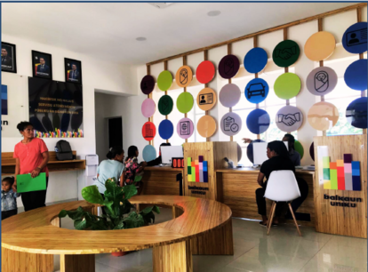 Photograph of a bright classroom with colorful circular wall displays and a round wooden table.