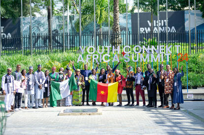 Photo: Diverse group outdoors in front of a building with a Youth Connect Africa Summit banner.