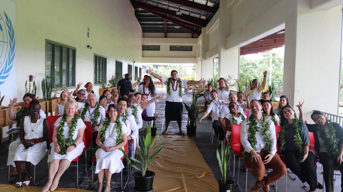 UNDP Samoa sitting in audience with man standing in the aisle