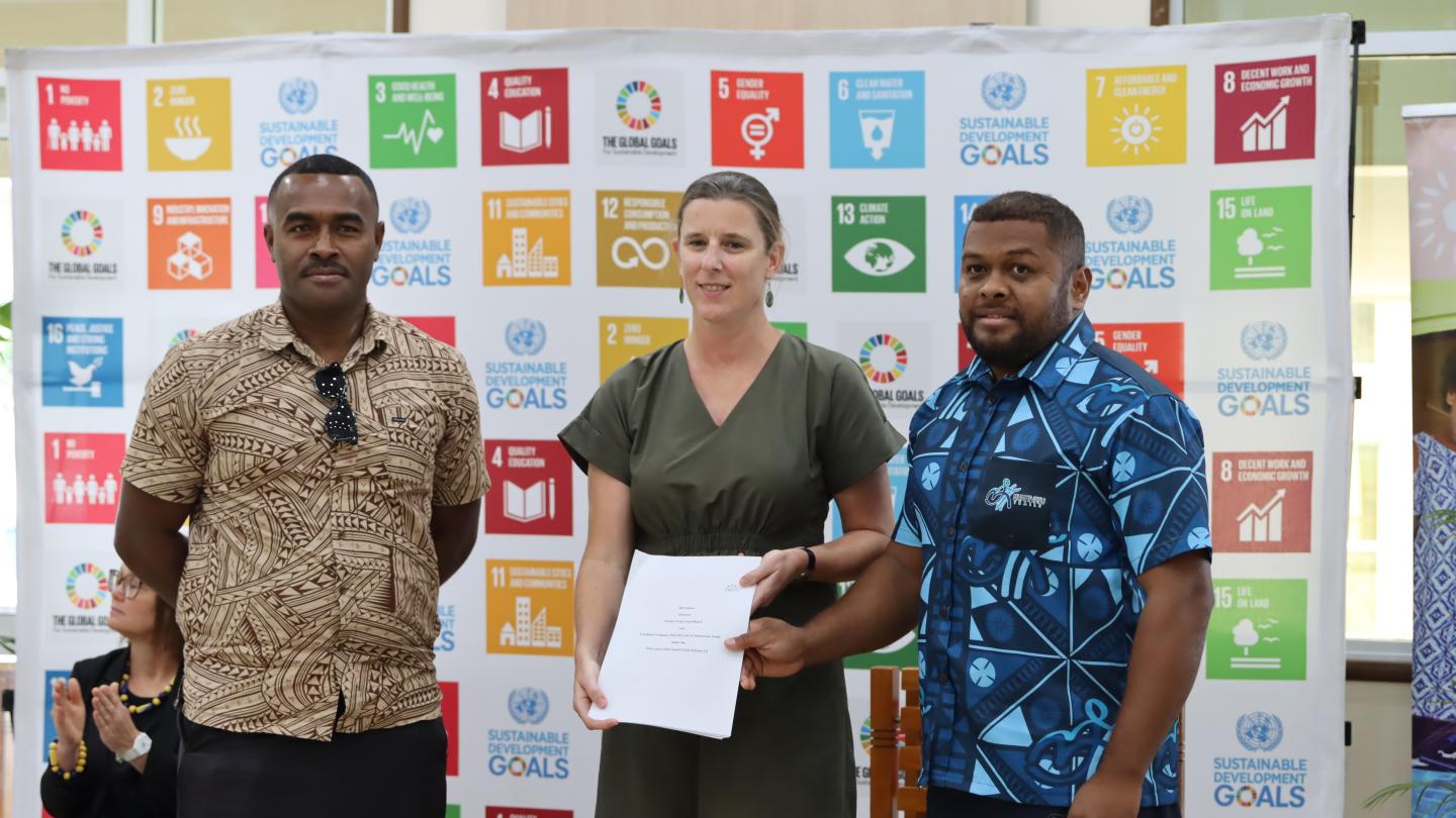 a group of men standing in front of a sign
