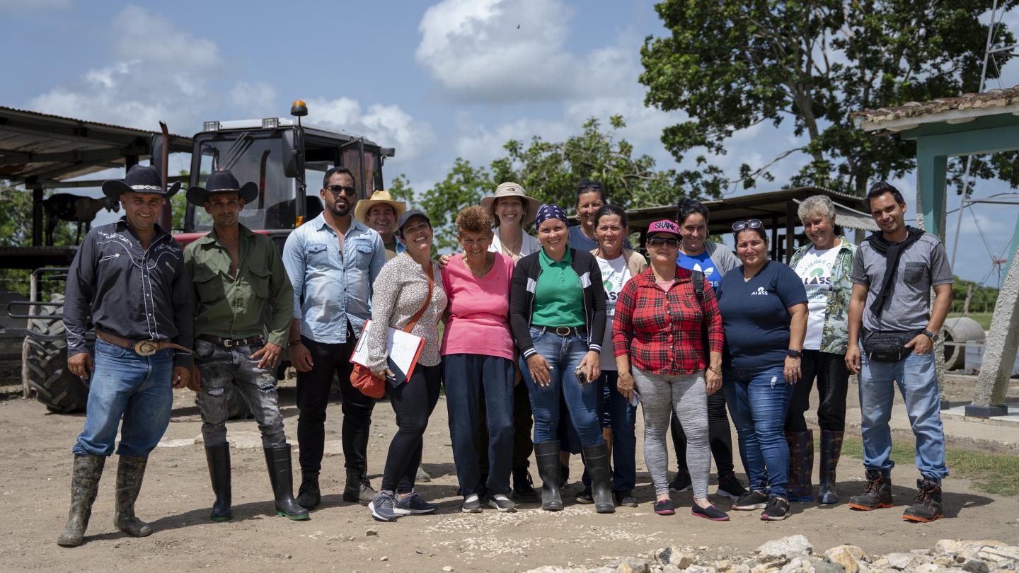 Un grupo de personas de pie frente a una multitud posando para la cámara