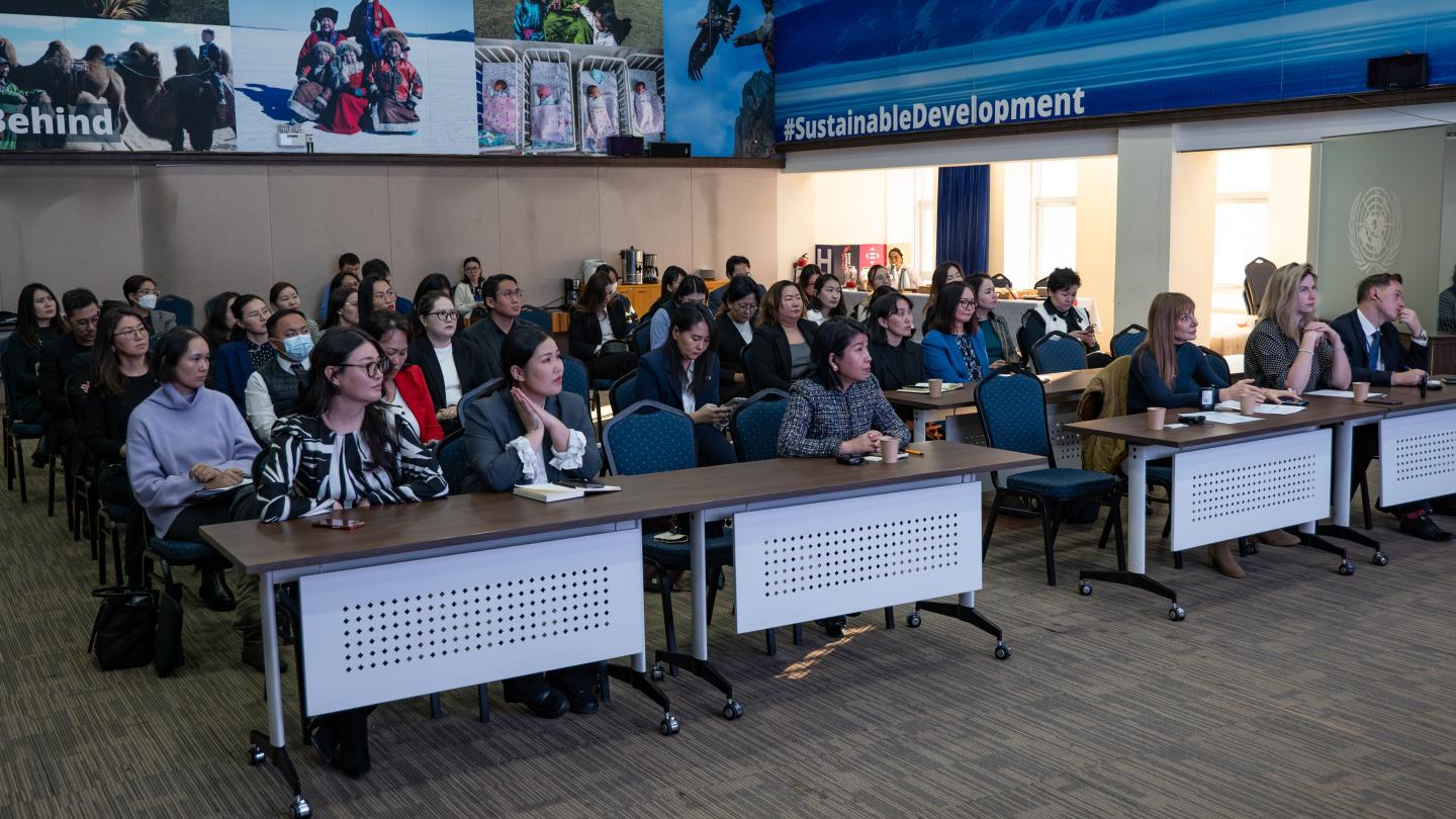 a group of people sitting at a desk in front of a crowd