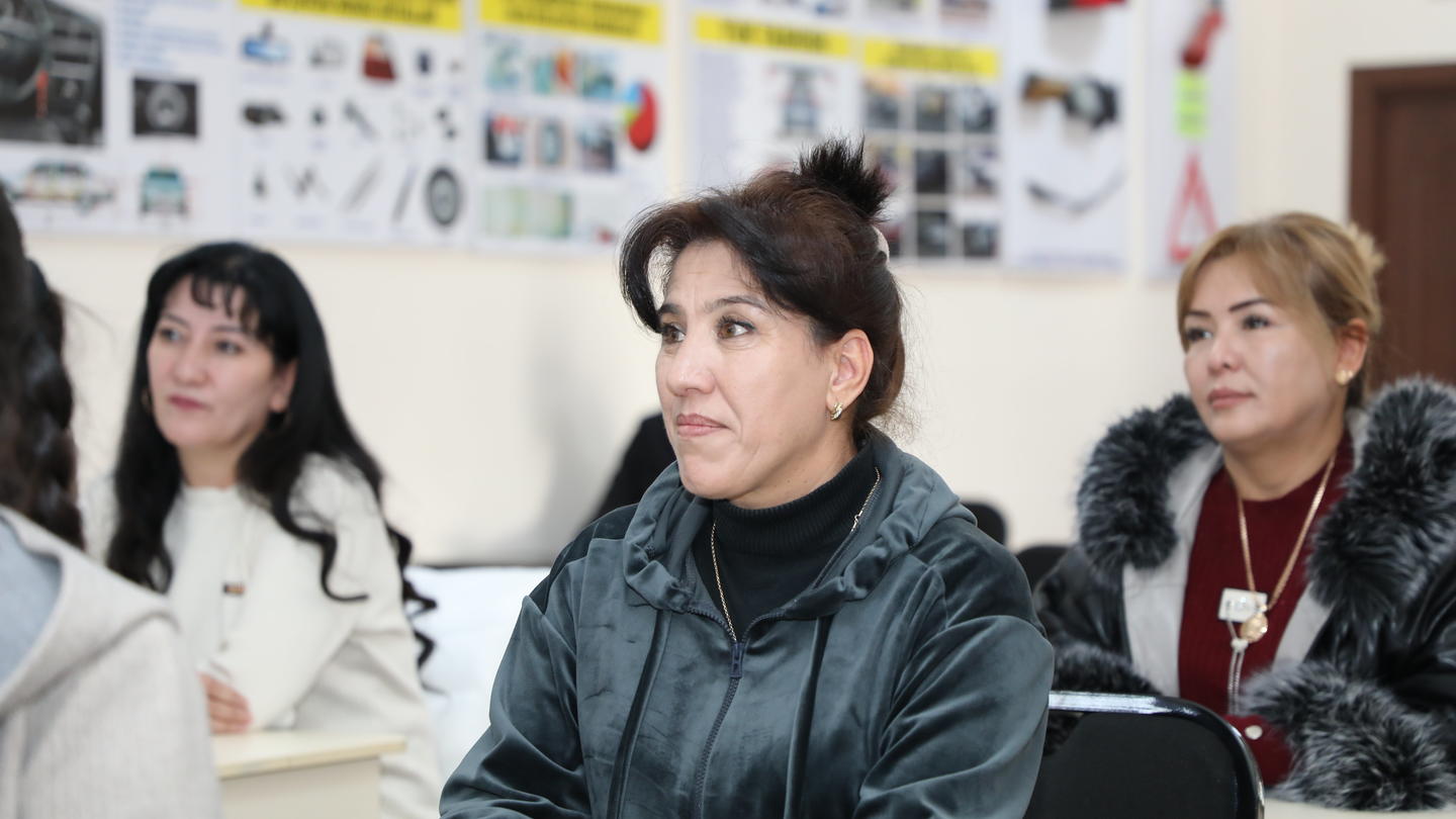 Photo of participants in a classroom workshop, posters on the back wall.