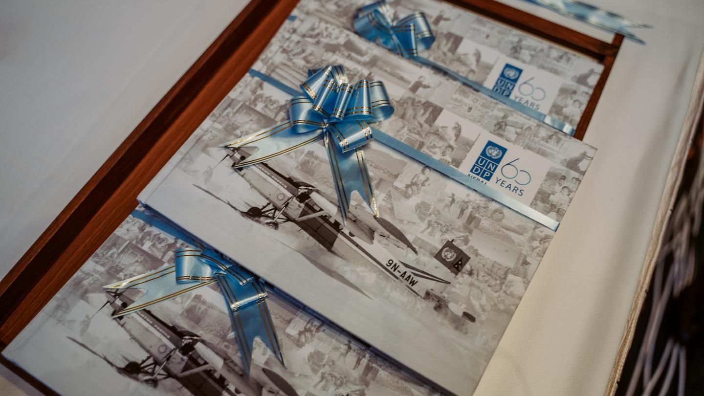 Wood-framed collage of black-and-white photos with blue geometric overlays.