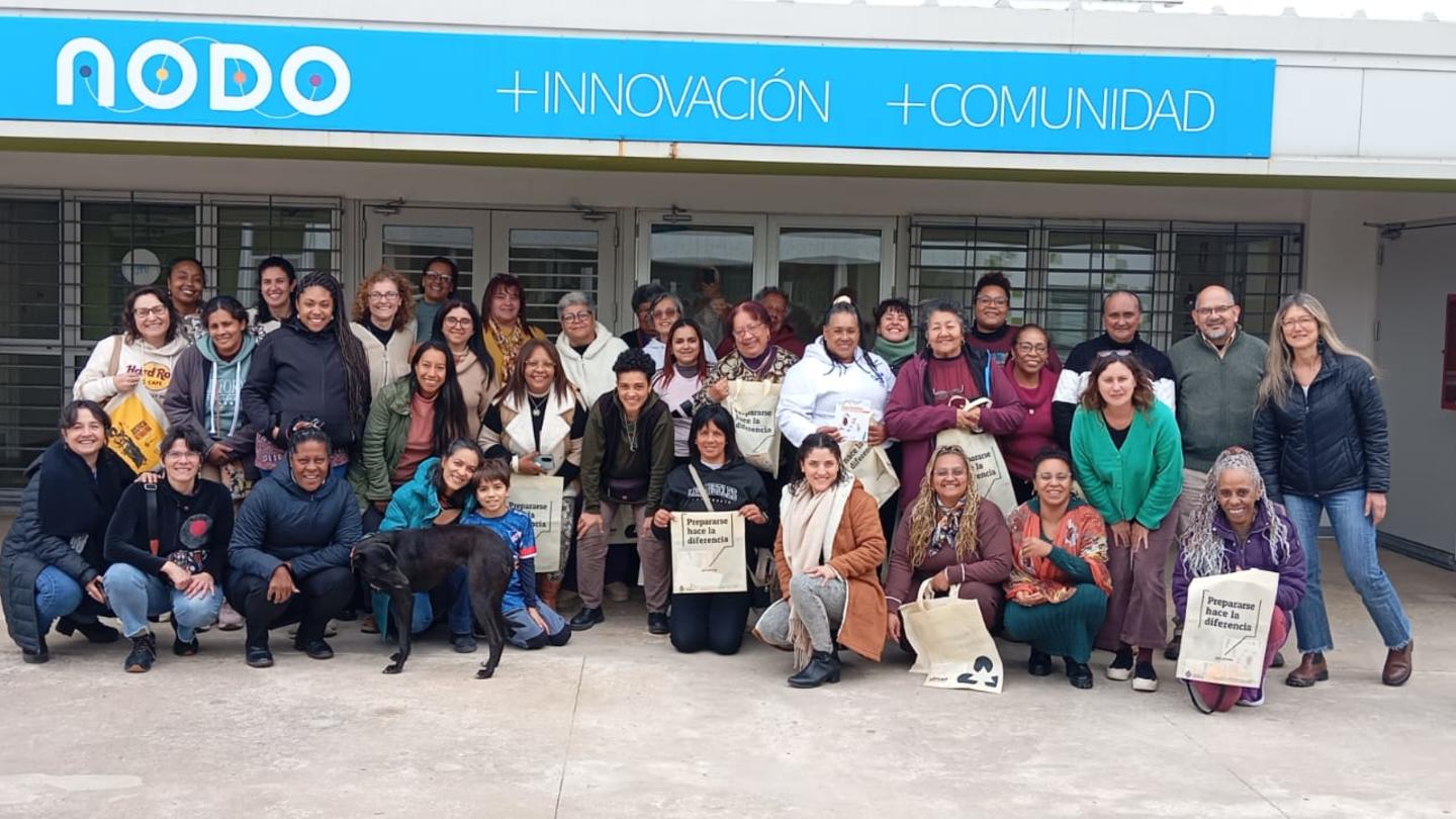 Group photo of diverse people posing outside a building with NODO signage.