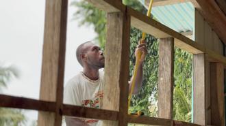 Construction worker erecting a wooden frame outdoors.